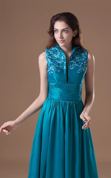 high-neck floor-length sleeveless dress with pleats and embroideries